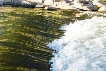 Smooth water with autumn tree reflected color flows into white rapids rushing on the Truckee river
