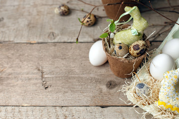 Easter composition of quail eggs and decorative bunny in flower potty on wooden background. Spring Holiday rustic traditional concept with copy space