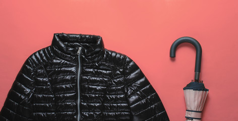 Fashionable women's clothing and accessories. Jacket, umbrella on pink background. Top view