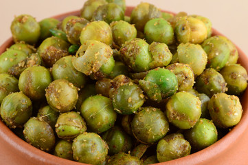 Spiced fried green peas {chatpata matar} Indian snack. Dried salted green peas in clay pot.