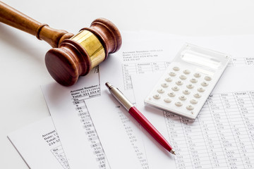 Taxes debt concept. Judge hammer near financial documents on grey background