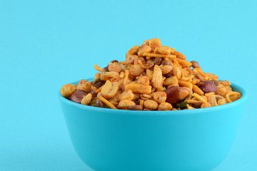 Indian Snacks : Mixture (roasted nuts with salt pepper masala, pulses, channa masala dal green peas) in blue bowl in