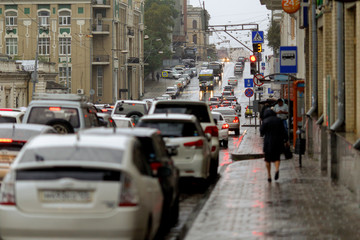 Streets of the city of Vladivostok wet from the rain. People walk along the wet streets of the central part of the city during the rain.