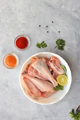 Clean and Raw Free range or country chicken carved in parts in a bowl with Indian spices and cooking ingredients. Along with copy space