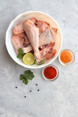 Clean and Raw Free range or country chicken carved in parts in a bowl with Indian spices and cooking ingredients. Along with copy space