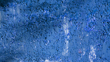 Texture of an old blue painted wall with peeling and cracked paint