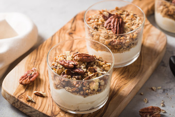 Delicious natural yogurt parfait with caramel, pecan nuts on conctere background