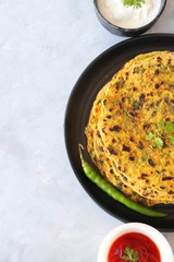 A Food called Methi paratha or Methi thepla is a Indian breakfast dish served with curd and ketchup. with copy space.