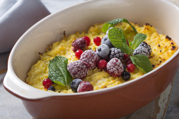 Cottage cheese casserole baked with  with fresh berries on kitchen table.