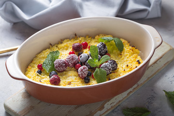 Cottage cheese casserole baked with  with fresh berries on kitchen table.