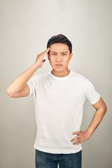 Obraz premium Good-looking asian man showing how much his head hurts, experiencing pain, looking miserable and exhausted