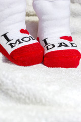Baby socks with loving parents text on white blank - copy space for text
