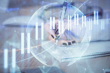 Multi exposure of hands making notes with forex chart huds. Stock market concept.