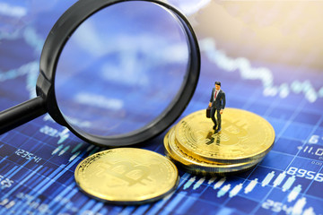 Miniature people : Businessman with Magnifying glass of bitcoin graph chart ,bitcoin Stock Market Analysis