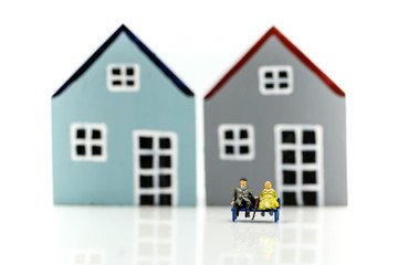Obraz na płótnie Canvas Miniature people : Family with house using as business, family and property concept.