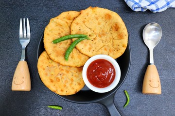 Freshly fried Masala stuffed Aloo puri or Kachori served hot with tomato ketchup and Green chilies