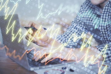Double exposure of forex graph with man working on computer on background. Concept of market analysis.