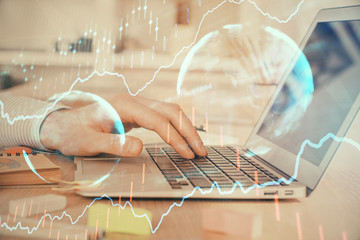 Double exposure of stock market graph with man working on laptop on background. Concept of financial analysis.