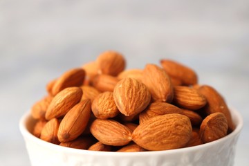 Almonds in white bowl on table. Almond Food or ingredient concept with copy space