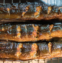 Fried gold scomber on the grill grid background on the Thailand city streets. Asian street food cuisine concept image.