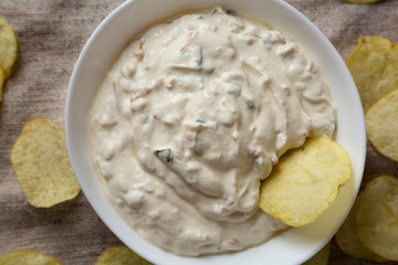 Homemade Caramelized Onion Dip with Potato Chips on cloth. Flat lay, top view, from above. Closeup.