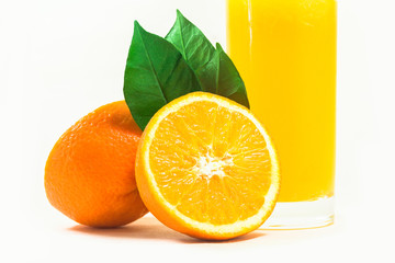 A cup of orange juice and cut orange on  white background.