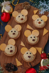 Tartlets Mice with cheese fo the New Year 2020 on wooden board on dark background, vertical orientation