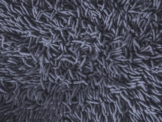 Dark gray doormat background. Soft brown doormat. Feels comfortable when using. close-up cleaning doormat or carpet texture.