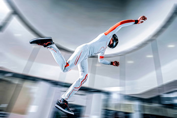 Skydiving. Freedom as a way of life. Parachutist performs an acrobatic trick in the air. Parachutist in white and orange suit. Skydiver is in free fall. 