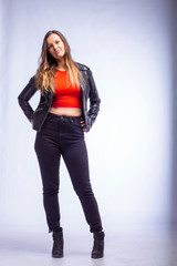 studio portrait of a young woman in a leather jacket on a white background