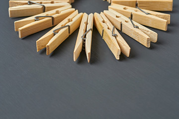 Many wooden clothespins in form of circle lies on dark concrete desk in bathroom. Space for text