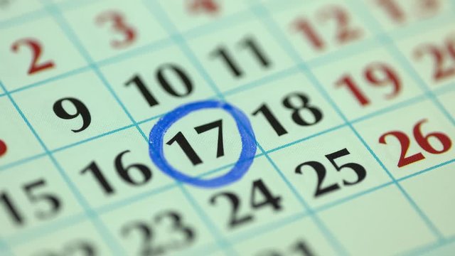 Marking the date in the calendar with a blue marker. The seventeenth day of the month