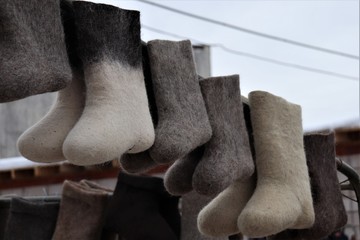Several pairs of Russian boots of different colors.