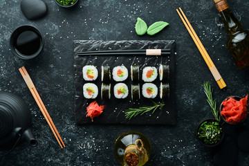 Sushi maki with salmon, avocado and nori. Free space for your text. Japanese Traditional Cuisine. Top view. Rustic style.