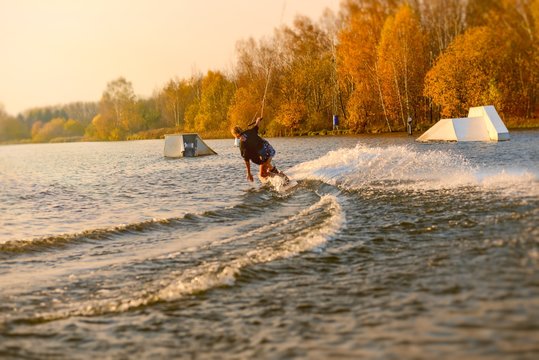Wakeboarder making tricks. Low angle shot of man wakeboarding on a lake.