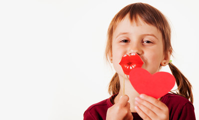 Valentines day and child carnival concept. Portrait of happy funny cute little girl with fake lips and red heart.