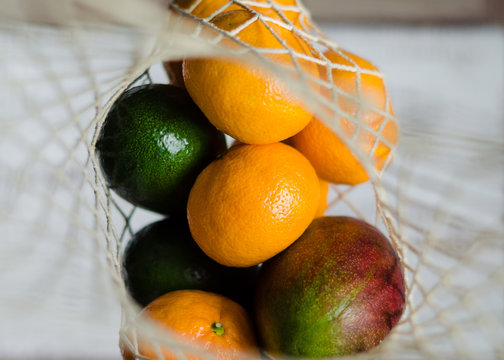 Fresh vegetables and fruits in the eco koton bag and net bag. Mesh bag with mango, avocado, apples, bell pepper and tangerines. Zero waste concept and plastic free.