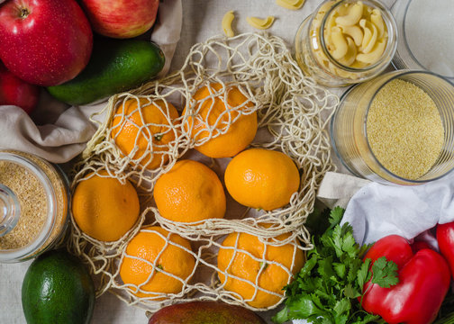Fresh vegetables and fruits in the eco koton bag and net bag. Mesh bag with mango, avocado, apples, bell pepper and tangerines. Zero waste concept and plastic free.