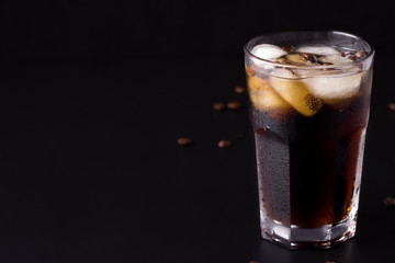 coffee with ice on a black background. There is a place for copy space.