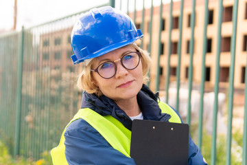 A woman Builder at a construction site inspects a house made of brick