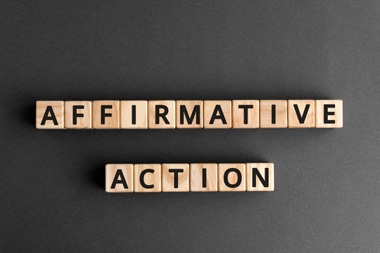 affirmative action- phrase words from wooden blocks with letters, affirmative action  support members of a disadvantaged group concept, top view gray background