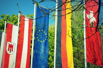 Flags of German-speaking countries Austria, Germany, and Switzerland next to the European Union flag.