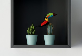 decorative cabinet with a wooden toucan sitting on two cactuses © Thomas