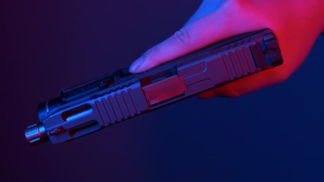 Racking the slide of a handgun to load a round in the chamber.