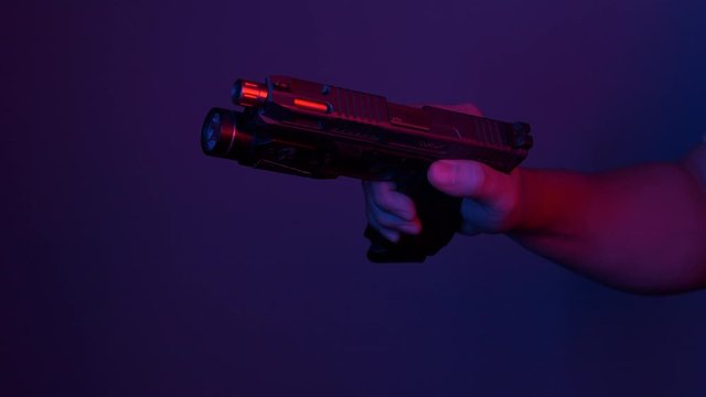 putting a magazine in a handgun and loading a round in the chamber.