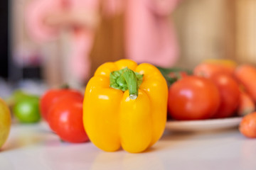 Vibrant yellow pepper on the table. Shallow focus
