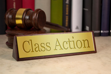 Golden sign with engraved word class action on a desk with gavel
