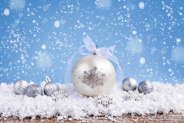Christmas composition with festive decorative balls on the snow. New Year greeting card.