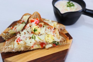 Chili Cheese toast, Open cheese sandwich or mini bread pizzas served with mayonnaise deep and garnished with chopped Basil leaves.