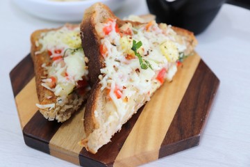 Chili Cheese toast, Open cheese sandwich or mini bread pizzas served with mayonnaise deep and garnished with chopped Basil leaves.
